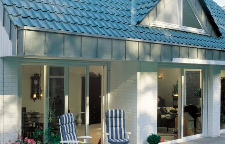 Terrassentüren mit weißem Rahmen in weißem Haus mit blauem Dach - Nötzel Fenster-Türen GmbH in Norderstedt